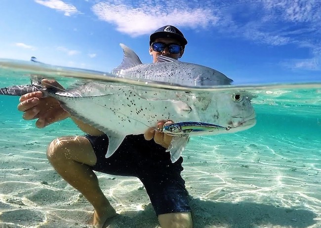 A guy among the crystal clear waters with his capture in Cozumel.