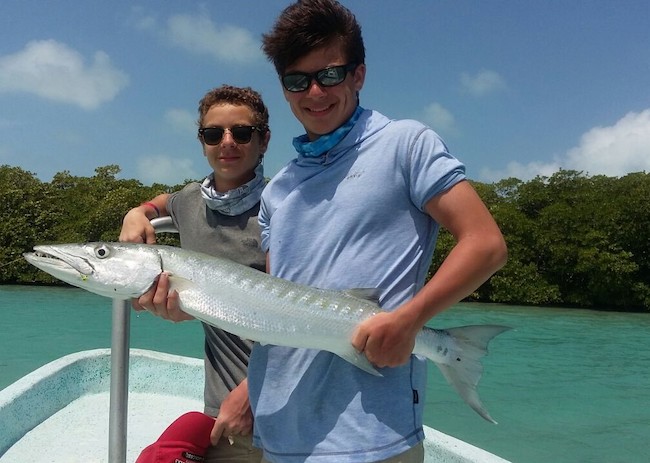 Children on a sunny day fishing in Cozumel.