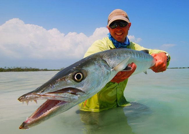 Larry showing off his catch over shallow waters in the island.