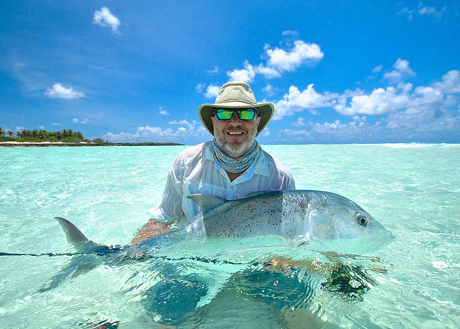 Christopher holding in the water his catch after a sunny day in Cozumel.