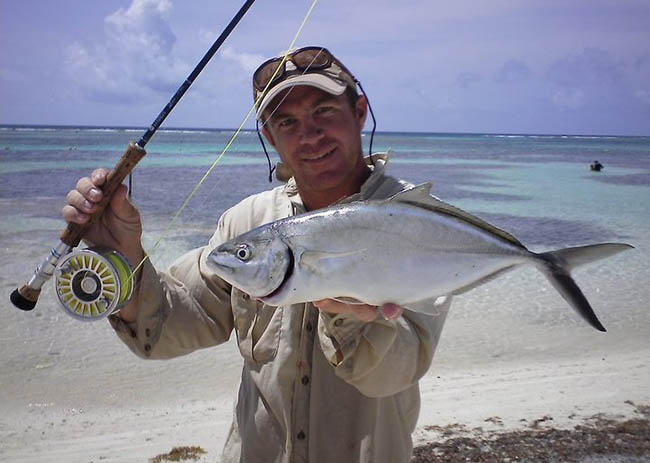 Daniel holding outside the water one of the fish he caught during his fly fishing tour.