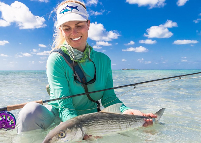Judy holding a fish she caught during her first fly fishing day in Cozumel.